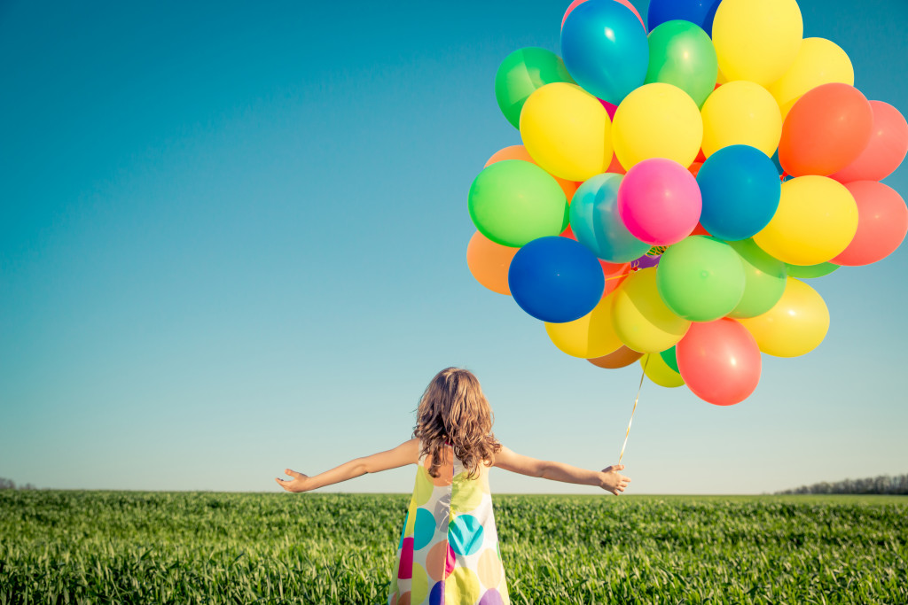 kid with balloons in hand